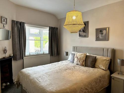 a bedroom with a large bed and a chandelier at A character property close to Lichfield Cathedral in Lichfield