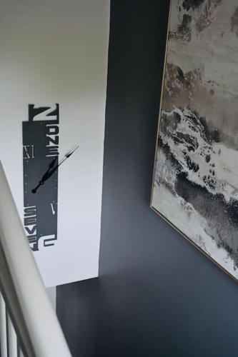 a clock on a wall next to a picture at Gaia in Lichfield