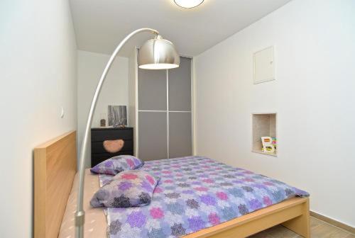 - une chambre avec un lit et des oreillers dans l'établissement Apartment Miha, à Loborika