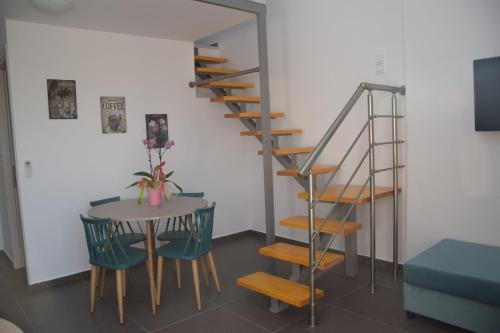 a room with a table and a spiral staircase at Olympia Suites in Pýrgos