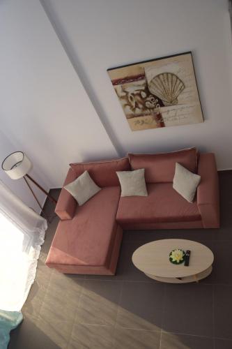 a living room with a brown couch and a table at Olympia Suites in Pýrgos
