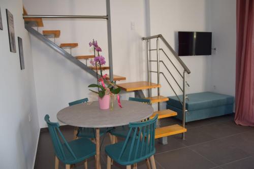 a table and chairs in a room with a staircase at Olympia Suites in Pýrgos