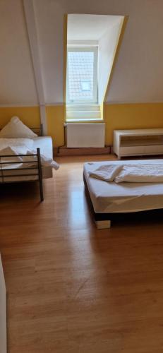 Zimmer mit 3 Betten und einem Fenster in der Unterkunft Zimmer mit eigenem Bad in Kaiserslautern