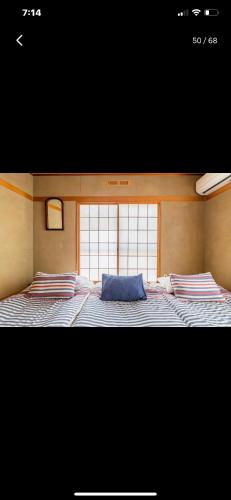 a large bed in a room with a window at Bonel Guest House in Tomisato