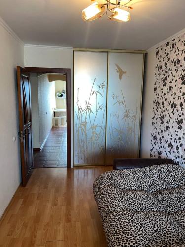 a bedroom with a bed and a sliding glass door at Двокімнатна квартира на Архипенко in Kyiv