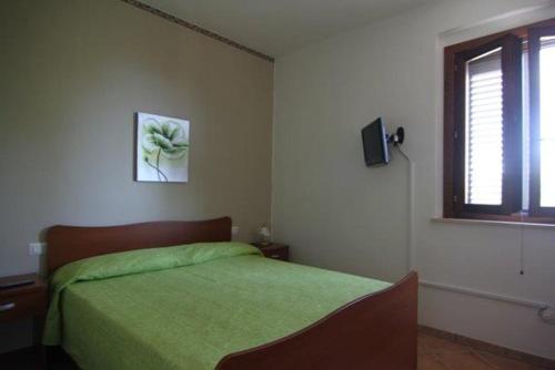 a bedroom with a green bed and a window at Costiera del Cilento Apartments in Casal Velino