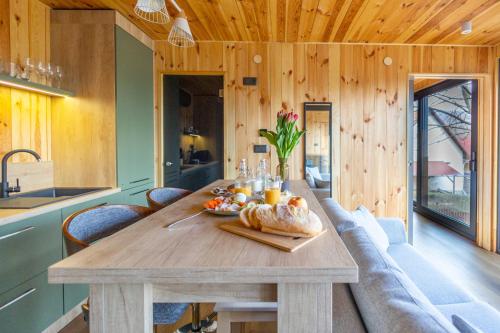 una mesa de madera en una cocina con techo de madera en Blackbox House Noszvaj, en Noszvaj