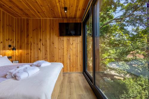 a bedroom with a bed and a large window at Blackbox House Noszvaj in Noszvaj