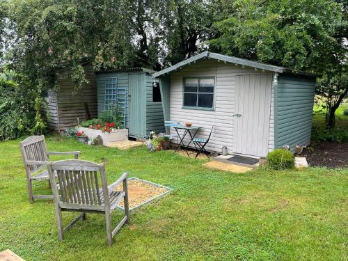 a yard with a bench and a shed at The Potting Shed in Manuden