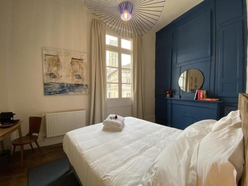- une chambre avec des murs bleus et un lit blanc dans l'établissement Les Chambres du Cloître, à Limoges