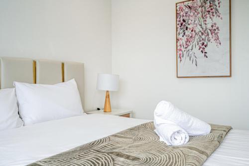 a bed with white pillows and a blanket on it at Spacious Modern 5Bedroom Retreat near Gregory Hill in Narellan