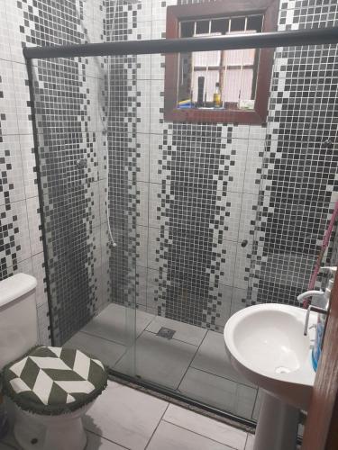 uma casa de banho com um chuveiro, um WC e um lavatório. em Junior doce lar em Resende