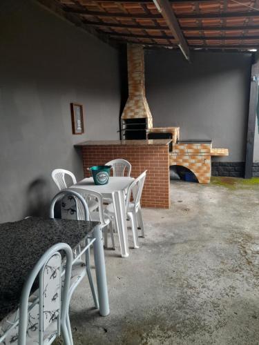 a white table and chairs in a room with a fireplace at Junior doce lar in Resende
