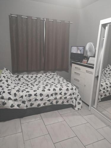 a bedroom with a bed and a dresser at Junior doce lar in Resende