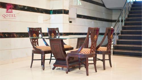 mesa de comedor y 4 sillas con encimera de cristal en Qotel Hotel Peeragarhi-Near Peeragarhi metro Station,Couple Friendly en Nueva Delhi