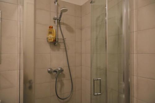 een badkamer met een douche en een glazen deur bij Studio in the city center in Rīga