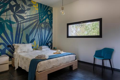een slaapkamer met een bed en een blauwe stoel bij B&B Coccaluto 39 in Castrignano deʼ Greci