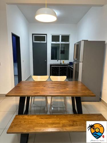 a kitchen with a wooden table and a refrigerator at ZZZ HOMESTAY SKUDAI in Skudai