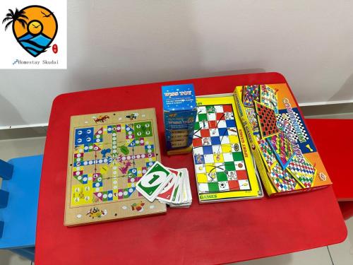 a red table with toys and games on it at ZZZ HOMESTAY SKUDAI in Skudai