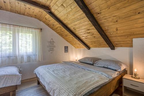 1 dormitorio con 1 cama grande y techo de madera en Holiday Home Primus, en Jastrebarsko
