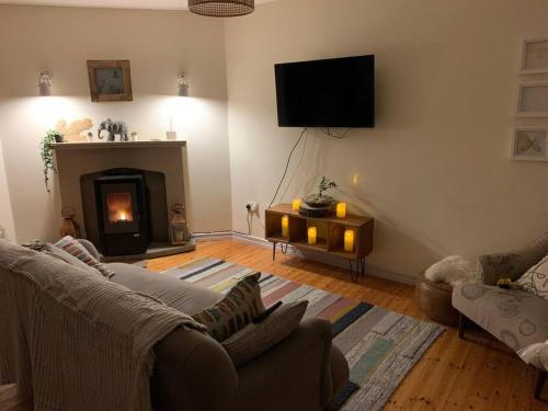 a living room with a couch and a fireplace at Roundstone Home with a Harbour and Mountain View in Roundstone
