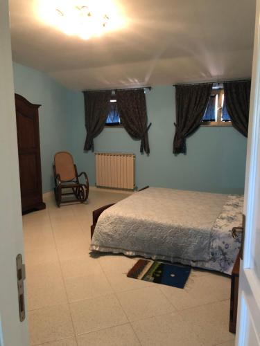 1 dormitorio con 1 cama, 1 silla y ventanas en B&B Boncore, en Montegranaro