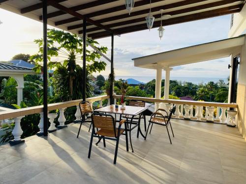 a patio with a table and chairs on a balcony at Oceanic View Apartments in Beau Vallon