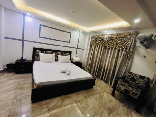 ein Schlafzimmer mit einem großen Bett und einem Stuhl in der Unterkunft Hotel Thanh Ngọc in Ho-Chi-Minh-Stadt