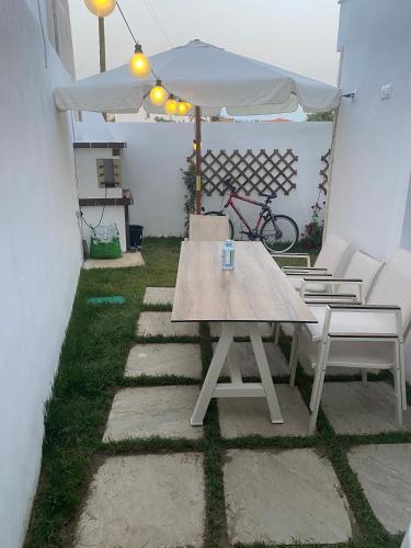 a picnic table and chairs under an umbrella on a patio at Momo's House in Nikiti