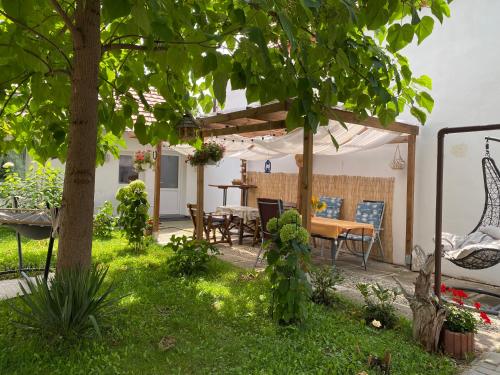 einen Garten mit einem Tisch und Stühlen unter einem Zelt in der Unterkunft Casa Tei in Turnişor