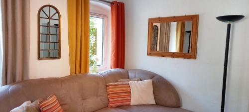 a living room with a brown couch and a mirror at Ferienhaus Peter in Weidenberg