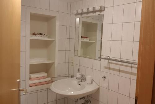 W białej łazience znajduje się umywalka i lustro. w obiekcie Familie Collato, zentralste Lage in Boppard w mieście Boppard