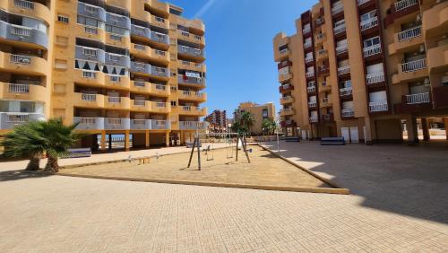 a playground in a courtyard in front of a building at La Manga del Mar Menor Los Miradores block 1 5th floor G in Murcia