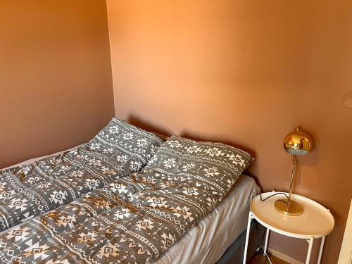 1 cama con 2 almohadas y una lámpara en una mesa en Solsiden, 2 soverom med parkering en Trondheim