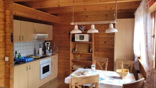 una cocina con paredes de madera y una mesa en una habitación en Ferienhaus Bliev-Hee Nr 4 en Klink