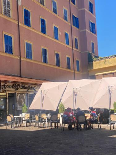 a group of people sitting at tables in front of a building at Fiuggiamo House in Fiuggi