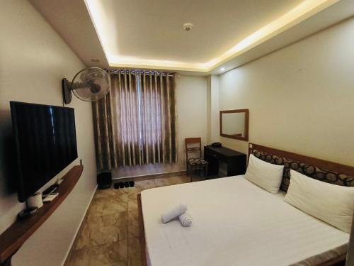 Schlafzimmer mit einem Bett und einem Flachbild-TV in der Unterkunft Hotel Thanh Ngọc in Ho-Chi-Minh-Stadt
