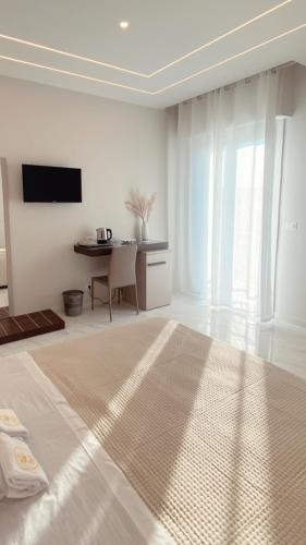 Habitación blanca con cama y mesa en Meligrana Central Rooms en Tropea