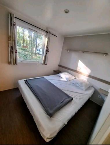une chambre avec un grand lit avec une fenêtre dans l'établissement Mobil Home 6 personnes 3 chambres à 25 MIN Puy duFou, à La Boissière-de-Montaigu