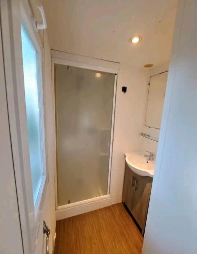 une salle de bain avec un lavabo et une grande fenêtre dans l'établissement Mobil Home 6 personnes 3 chambres à 25 MIN Puy duFou, à La Boissière-de-Montaigu