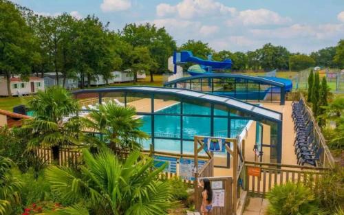 a large swimming pool at a resort with two slides at Mobil Home 6 personnes 3 chambres à 25 MIN Puy duFou in La Boissière-de-Montaigu