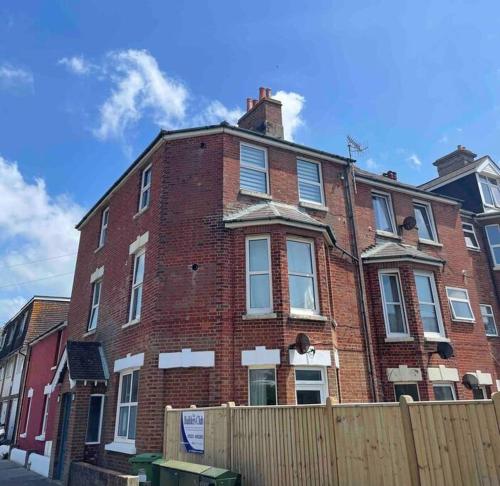 a red brick building with a fence in front of it at The Claremont, Seaford, South Downs, Seaside Town in Seaford