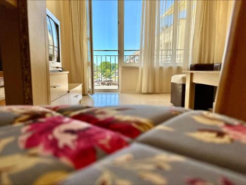 um quarto com uma cama e vista para uma varanda em Blue Marine - Menada Apartments em Sunny Beach