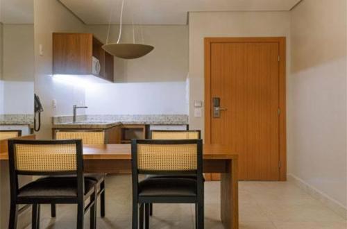 a kitchen with a table and chairs and a door at Salinas Exclusive Resort in Salinópolis