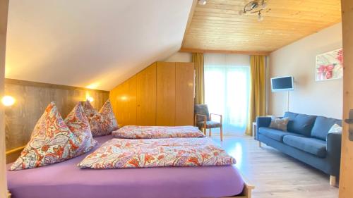 a bedroom with a bed and a blue couch at Gästehaus Rader in Weissbriach