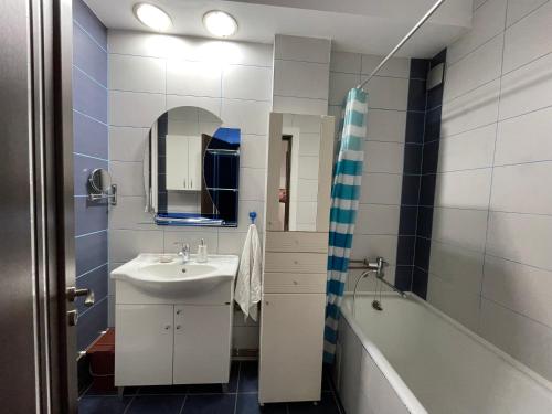 La salle de bains est pourvue d'un lavabo et d'une baignoire. dans l'établissement Relax Old Town Apartment, à Oradea