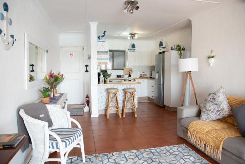 a living room with a couch and a kitchen at Macs Cove, Marina Martinique in Jeffreys Bay