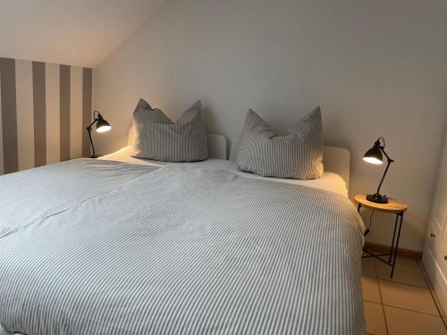 a bedroom with a large white bed with two pillows at Weberhof - Münster 5 in Münster