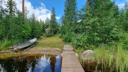 een boot is aangemeerd naast een houten brug bij Villa Helmi in Jämsä