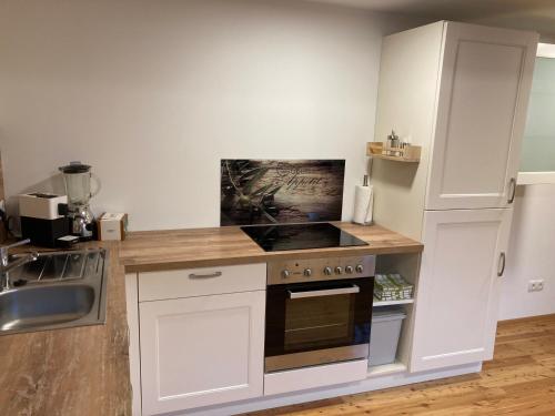 a kitchen with white cabinets and a stove top oven at Bandltroga in Murau